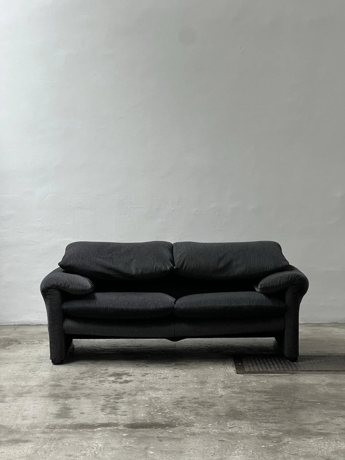 Canapé 2 places au design épuré signé Enzo Magistretti pour Cassina.