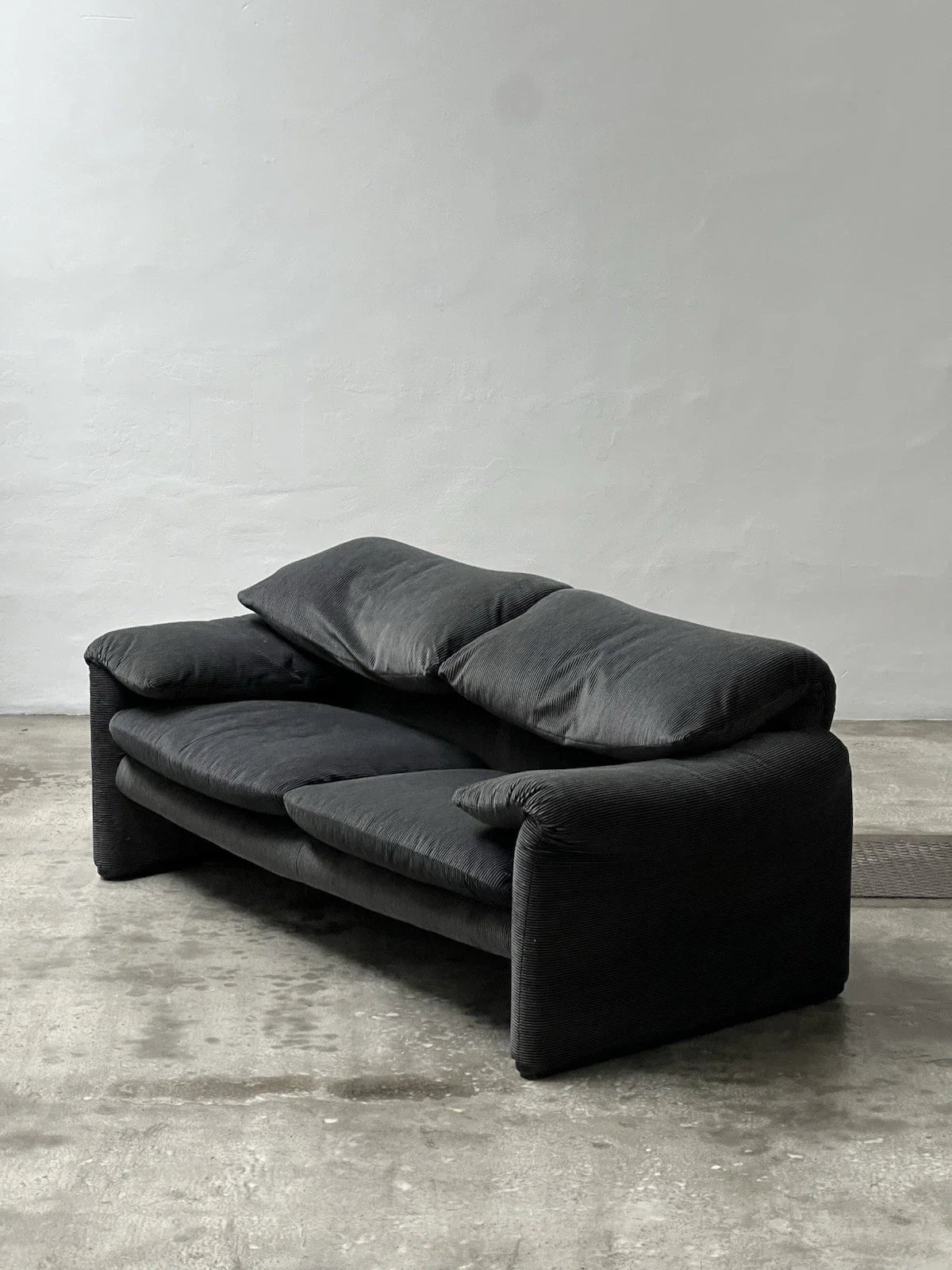Canapé 2 places au design épuré signé Enzo Magistretti pour Cassina.