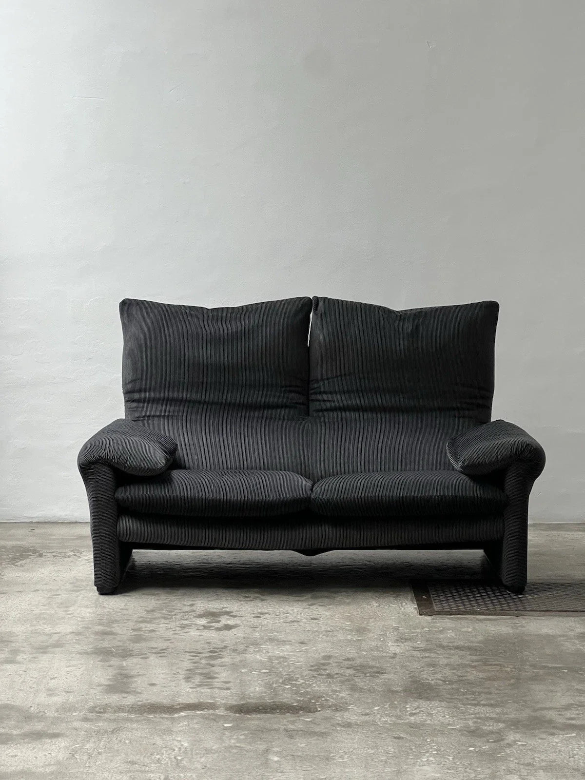 Canapé 2 places au design épuré signé Enzo Magistretti pour Cassina.