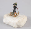 Sculpture miniature antique autrichienne en bronze représentant un teckel faisant du traîneau dans la neige.
